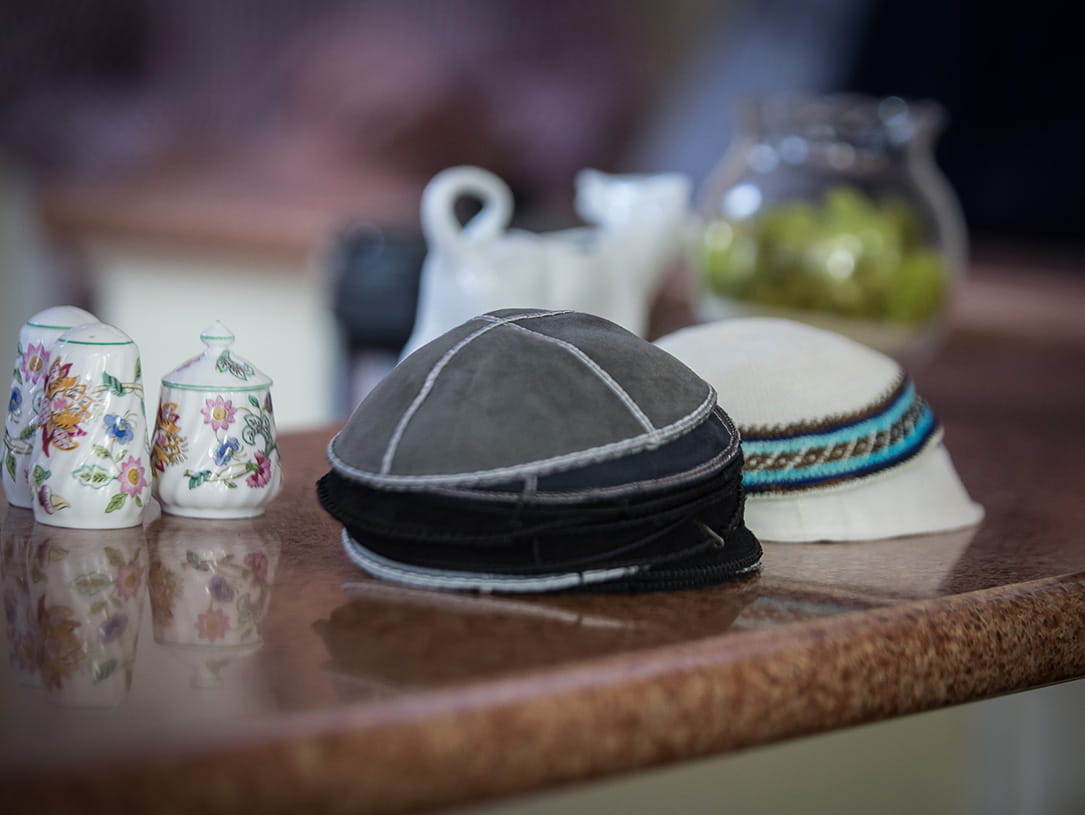 Kippot auf einem Tresen liegend mit Porzellan daneben