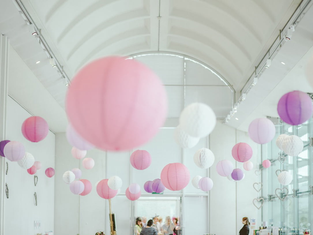 Mit rosafarbenen, lilafarbenen und weißen Papierlaternen dekorierter Veranstaltungsraum