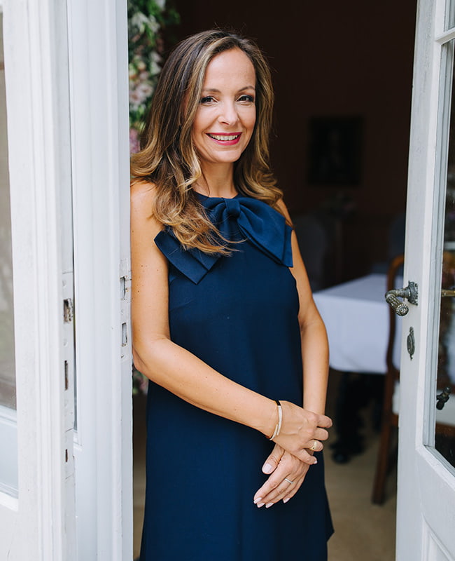 Kristin Dorst in dunkelblauem Kleid in einer geöffneten Tür