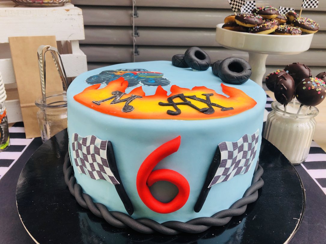 Geburtstagstorte im Rennfahrer-Stil mit Donuts und Cakepops im Hintergrund