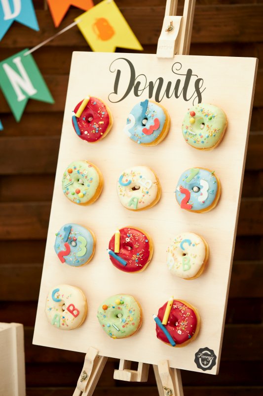 Bunte Donuts hängen an einer Donuts-Tafel